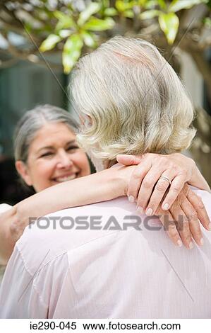 Stock Photography - A senior womans with her arms around a senior man. Fotosearch