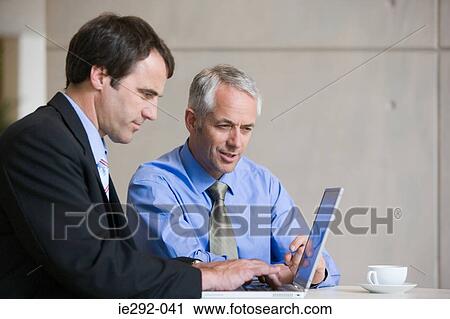 Businessmen using a laptop computer View Large Photo Image Stock Image - Businessmen using a laptop computer. Fotosearch