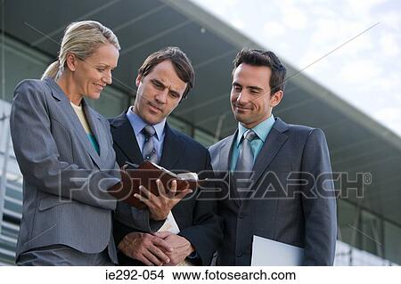 Picture - Colleagues looking at orgainzer. Fotosearch