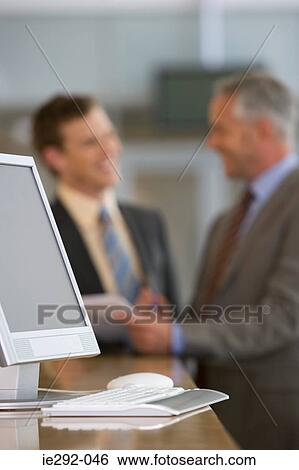 Computer with businessmen in background View Large Photo Image Stock Photograph - Computer with businessmen in background. Fotosearch