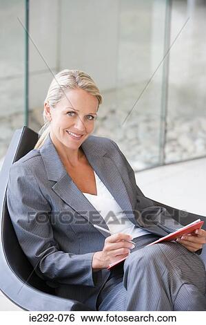 Smiling businesswoman with clipboard View Large Photo Image Stock Photograph - Smiling businesswoman with clipboard. Fotosearch