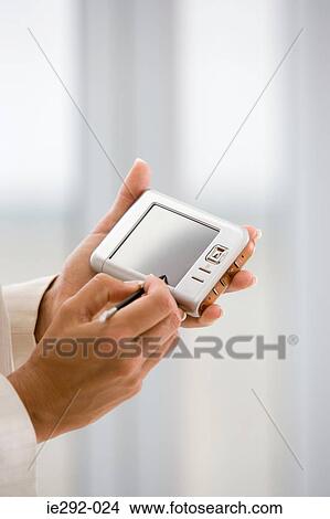 Picture - Woman holding a handheld computer. Fotosearch
