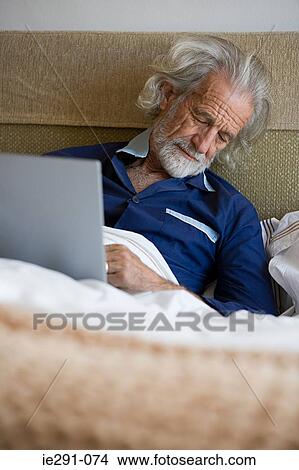 Man in bed with laptop View Large Photo Image Picture - Man in bed with laptop. Fotosearch