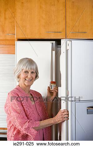Senior woman by refrigerator View Large Photo Image Stock Photography - Senior woman by refrigerator. Fotosearch
