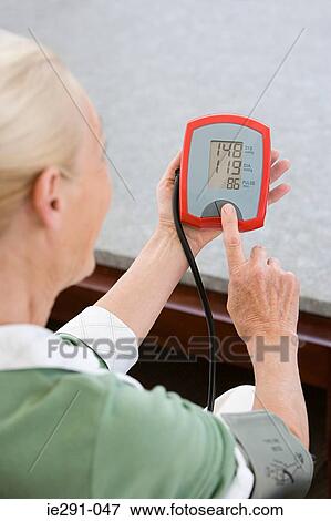 Woman using blood pressure gauge View Large Photo Image Stock Photo - Woman using blood pressure gauge. Fotosearch