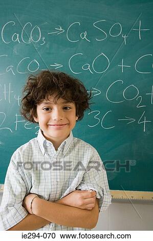 Boy standing by blackboard View Large Photo Image Stock Image - Boy standing by blackboard. Fotosearch