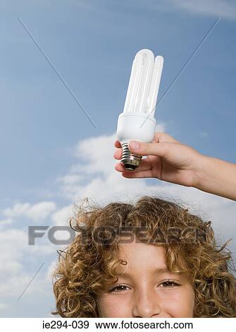 Boy with lightbulb above head View Large Photo Image Stock Photo - Boy with lightbulb above head. Fotosearch