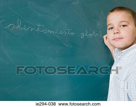 Boy writing on a blackboard View Large Photo Image Stock Photo - Boy writing on a blackboard. Fotosearch
