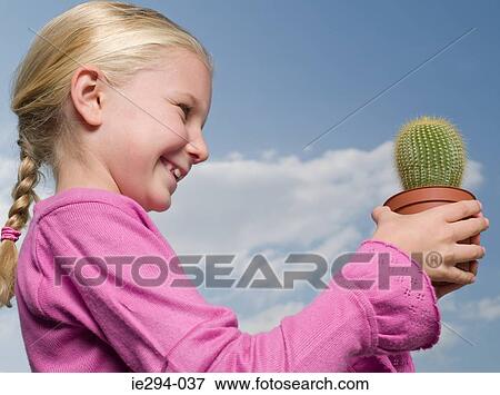 Girl holding a cactus View Large Photo Image Stock Photo - Girl holding a cactus. Fotosearch