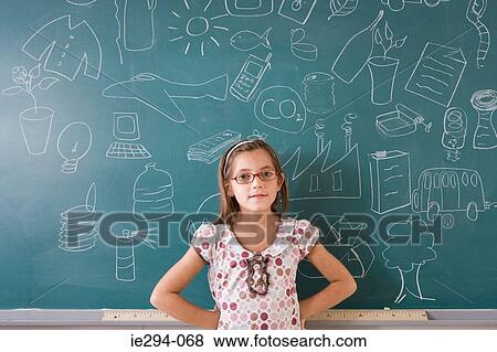 Stock Photo - Girl standing by blackboard. Fotosearch