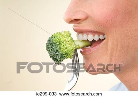 A woman eating broccoli View Large Photo Image Stock Image - A woman eating broccoli. Fotosearch