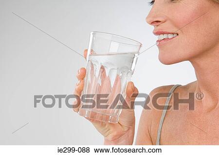 A woman holding a glass of water View Large Photo Image Stock Photo - A woman holding a glass of water. Fotosearch