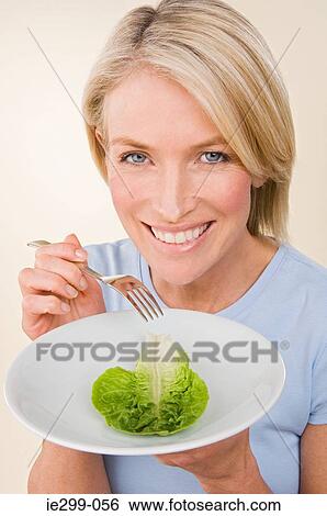 A woman holding a plate with a lettuce View Large Photo Image Stock Photograph - A woman holding a plate with a lettuce. Fotosearch