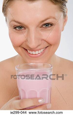 A woman holding a strawberry milkshake View Large Photo Image Picture - A woman holding a strawberry milkshake. Fotosearch