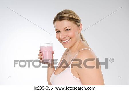 Stock Photography - A woman holding a strawberry milkshake. Fotosearch
