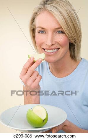 A woman holding an apple View Large Photo Image Stock Photography - A woman holding an apple. Fotosearch