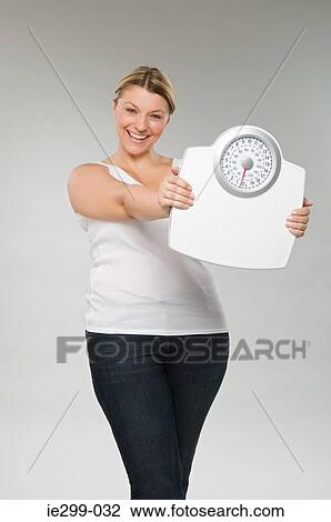 A woman holding weight scales View Large Photo Image Stock Image - A woman holding weight scales. Fotosearch