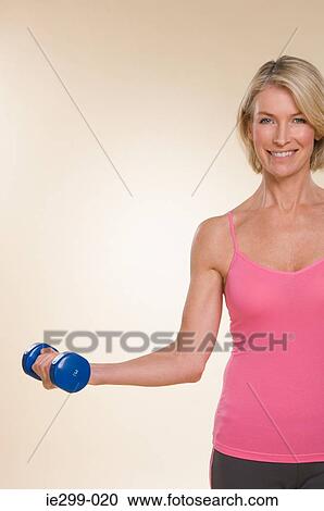 A woman lifting dumbbells View Large Photo Image Stock Image - A woman lifting dumbbells. Fotosearch