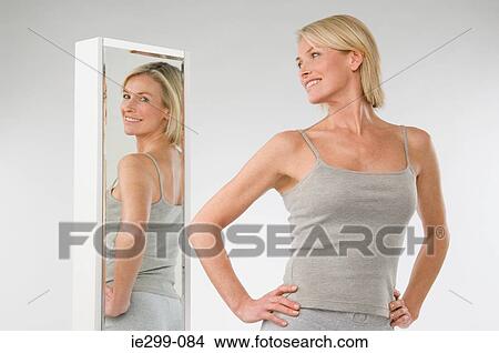 Picture - A woman looking in a mirror. Fotosearch