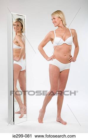 A woman looking in a mirror View Large Photo Image Stock Image - A woman looking in a mirror. Fotosearch