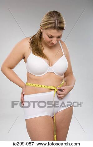 A woman measuring her waist View Large Photo Image Stock Photo - A woman measuring her waist. Fotosearch