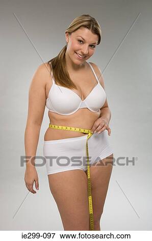 A woman measuring her waist View Large Photo Image Stock Photo - A woman measuring her waist. Fotosearch