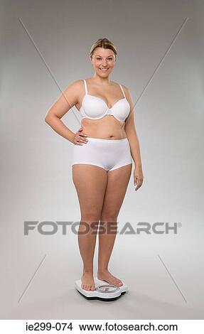 A woman weighing herself View Large Photo Image Picture - A woman weighing herself. Fotosearch