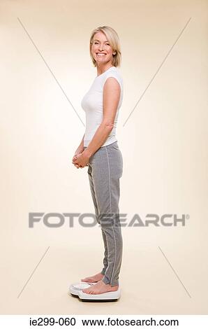 A woman weighing herself View Large Photo Image Stock Image - A woman weighing herself. Fotosearch