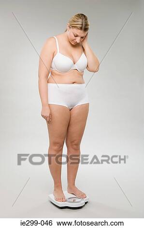 A woman weighing herself View Large Photo Image Stock Photograph - A woman weighing herself. Fotosearch