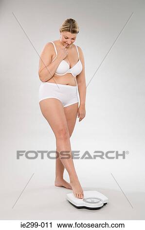 An anxious woman weighing herself View Large Photo Image Stock Image - An anxious woman weighing herself. Fotosearch
