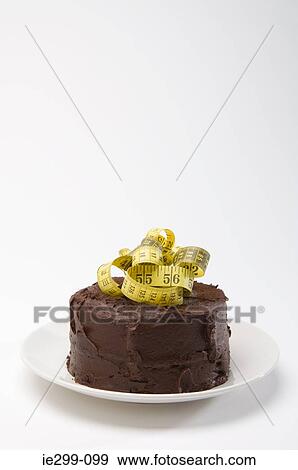 Chocolate cake and a tape measure View Large Photo Image Stock Photo - Chocolate cake and a tape measure. Fotosearch