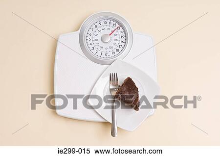Stock Photography - Chocolate cake on weight scales. Fotosearch