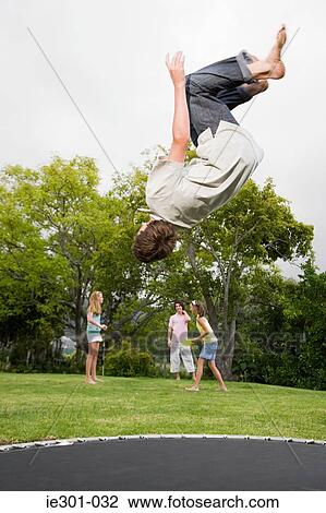 A teenage boy doing somersaults on a trampoline View Large Photo Image Stock Image - A teenage boy doing somersaults on a trampoline. Fotosearch