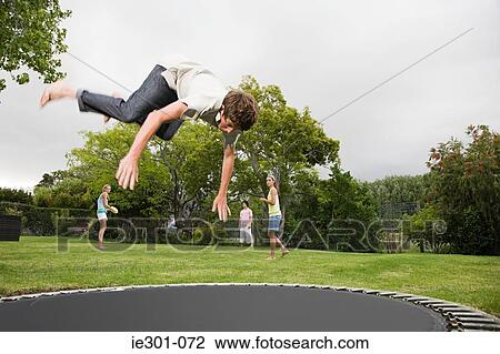 A teenage boy doing somersaults on a trampoline View Large Photo Image Stock Image - A teenage boy doing somersaults on a trampoline. Fotosearch