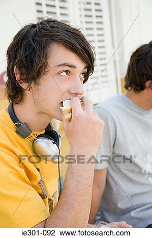 A teenage boy eating a sandwich View Large Photo Image Stock Image - A teenage boy eating a sandwich. Fotosearch