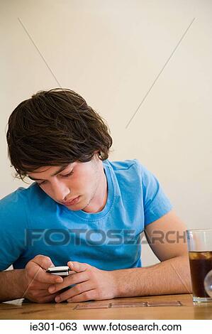 A teenage boy using a cell phone View Large Photo Image Stock Image - A teenage boy using a cell phone. Fotosearch