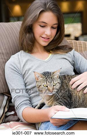 A teenage girl stroking a cat View Large Photo Image Stock Photo - A teenage girl stroking a cat. Fotosearch