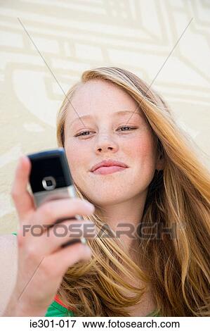 A teenage girl using a cell phone View Large Photo Image Stock Photo - A teenage girl using a cell phone. Fotosearch
