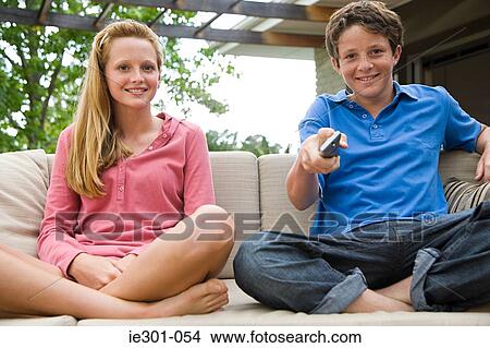 Teenage boy and girl watching tv View Large Photo Image Picture - Teenage boy and girl watching tv. Fotosearch