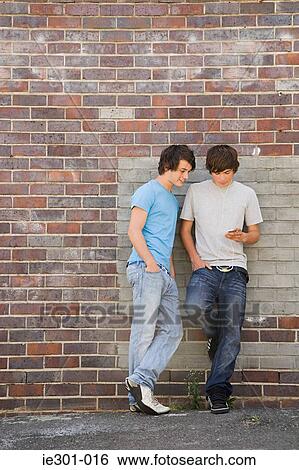 Stock Photograph - Teenage boys leaning against a wall. Fotosearch