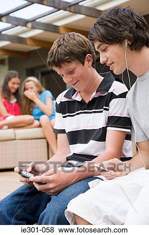 Teenage boys listening to music and playing a video game View Large Photo Image Stock Photo - Teenage boys listening to music and playing a video game. Fotosearch