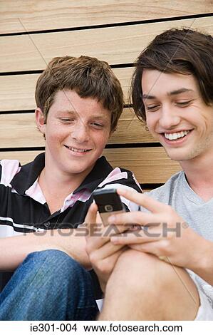 Teenage boys using a cell phone View Large Photo Image Picture - Teenage boys using a cell phone. Fotosearch
