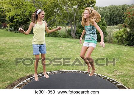 Teenage girls jumping on a trampoline View Large Photo Image Stock Image - Teenage girls jumping on a trampoline. Fotosearch
