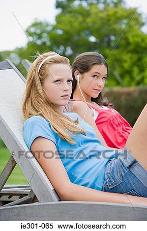 Stock Photography - Teenage girls listening to music. Fotosearch