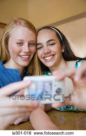 Stock Photo - Teenage girls photographing themselves. Fotosearch