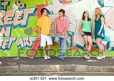 Stock Image - Teenagers leaning against a wall. Fotosearch