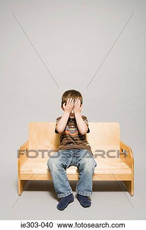Stock Image - A boy covering his eyes. Fotosearch