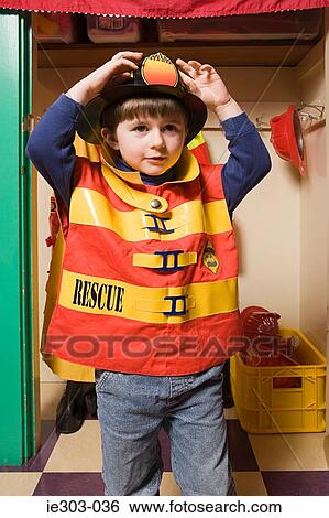 Stock Photograph - A boy pretending to be a firefighter. Fotosearch