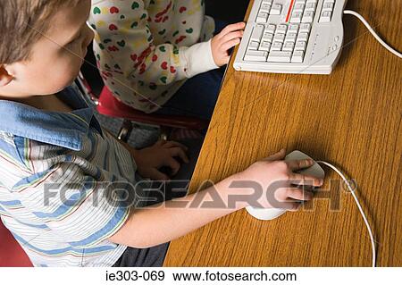 A boy using a computer mouse View Large Photo Image Stock Photo - A boy using a computer mouse. Fotosearch