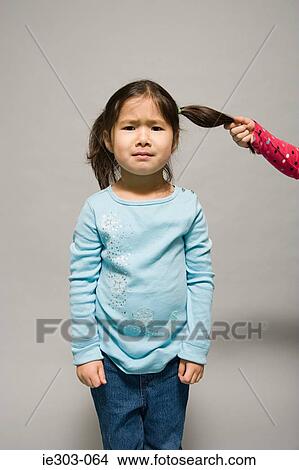 A girl having her hair pulled View Large Photo Image Picture - A girl having her hair pulled. Fotosearch